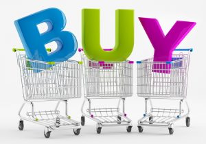 Three shopping carts with large letters BUY to show the Shopping Habits of Wealthy Consumers