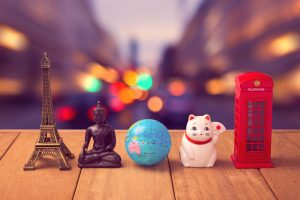 Travel around the world concept. Souvenirs from around the world on wooden table over city bokeh background to show how travelers can