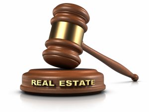 Gavel and "REAL ESTATE" word writing on sound block to show real estate laws